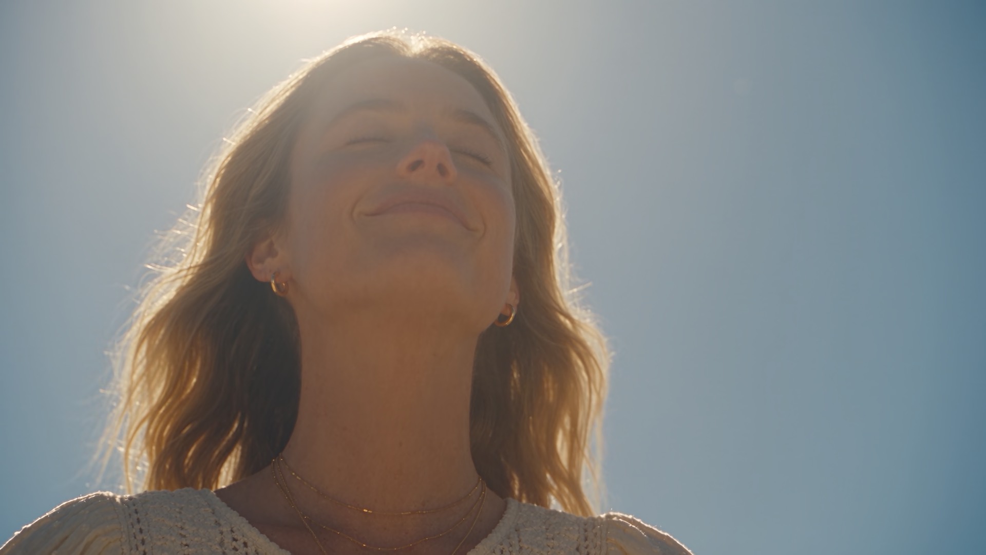 The same mother, eyes closed, smiling with her face turned up into the sun